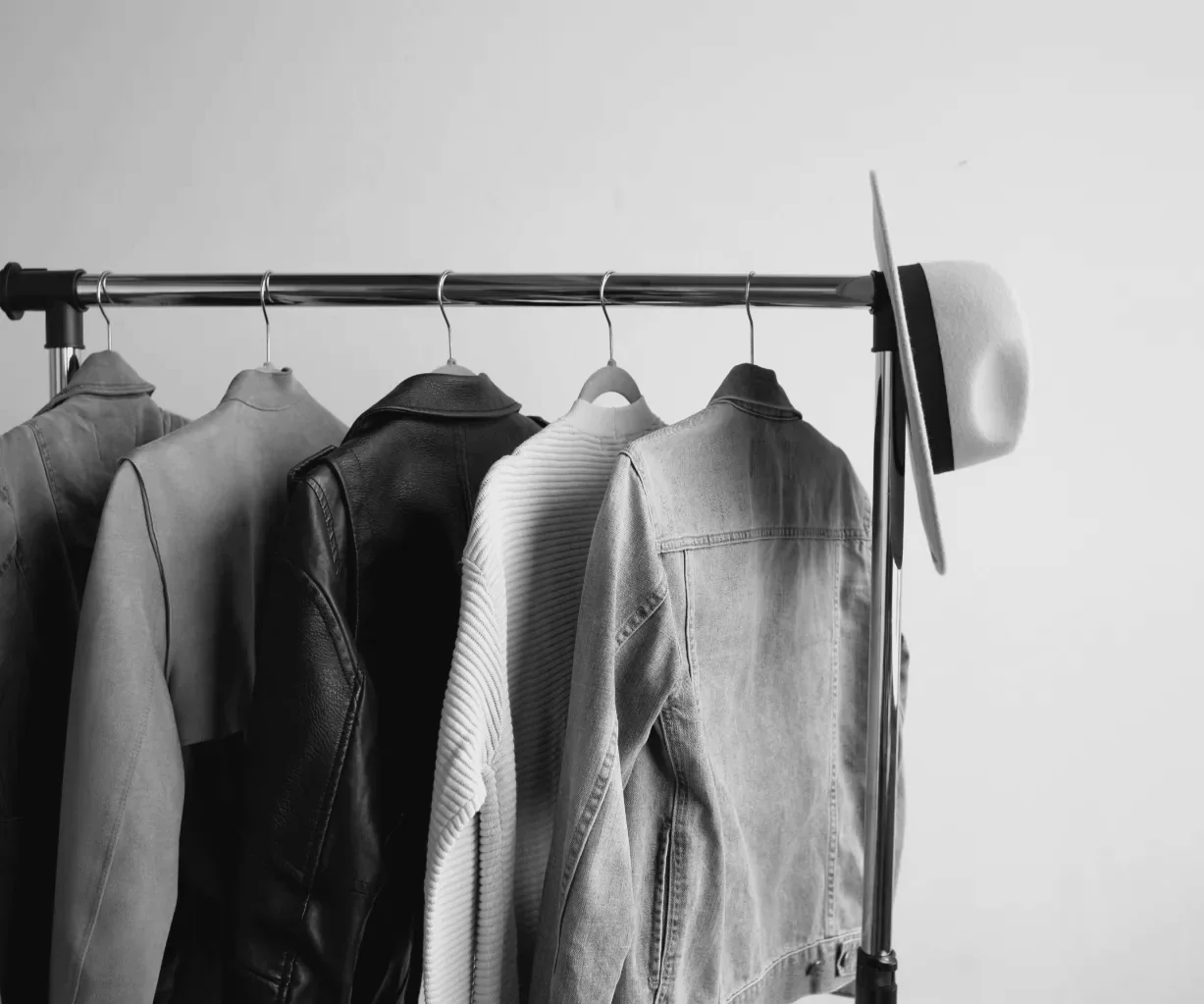 Jackets and a hat on a clothing rail, black and white